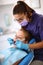 Female dentist repairing child`s tooth