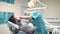 Female dentist sits down and examining teeth of male patient.