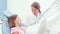 Female dentist talking with little girl in dental chair