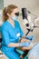 Female dentist treating caries using microscope at the dentist office