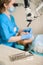 Female dentist treating caries using microscope at the dentist office