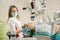 Female dentist treating caries using microscope at the dentist office