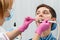 Female dentist is treating a patient tooth in dental office wit