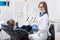 Female dentists examining and working with boy patient. Kid boy in dentist`s chair