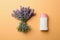Female deodorant and lavender flowers on apricot background