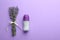 Female deodorant and lavender flowers on lilac background. Space for text