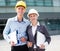 Female designer and her partner are standing with laptop and folder