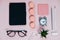 Female Desk on pink glasses notepad kicking pencils plant macaroons alarm clock Top View Space For Text