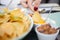 Female dipping a crisp in a yellow sauce