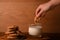 Female dipping a piece of peanut chocolate cookie in a glass of milk