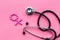 Female diseases concept. Stethoscope near female sign on pink background top view