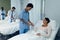 Female doctor attaching pulse oximetry on female patient hand in the ward