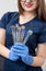 Female doctor with blue gloves holding tools - dental mirrors and dental sondes at the dental office