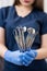 Female doctor with blue gloves holding tools - dental mirrors and dental sondes at the dental office