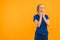 Female doctor in blue using a Stethoscope and looking at the camera - closeup orange background