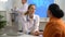 Female doctor calms her elderly patient and holding her hand.