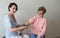 Female doctor checking blood pressure elderly woman