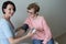 Female doctor checking blood pressure elderly woman