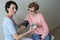 Female doctor checking blood pressure elderly woman