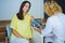 Female doctor checking young woman blood pressure