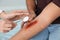 Female doctor cleaning young man`s arm injury in clinic, closeup.