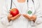 Female doctor compare pile of pills with fresh apple