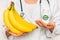 Female doctor compare pile of pills with fresh banana