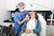 Female doctor cosmetologist performing machine facial procedure to mature woman in clinic