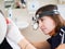 Female doctor with a device on her head works with the patientâ€™s ear intently