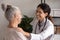 Female doctor encourage unhealthy senior lady at appointment in hospital