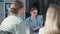 female doctor with eyeglasses and phonendoscope advising a married couple on womens health in hospital cabinet