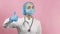 Female doctor in face mask and medical gloves showing hand gesture thumbs up