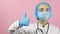 Female doctor in face mask and medical gloves showing hand gesture thumbs up