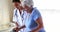 Female doctor helping senior woman to walk with a walker