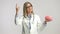 Female doctor holding a brain model and pointing up with her finger