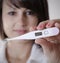 Female doctor holding medical thermometer