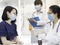 Female doctor holding pill bottle explains how to take medicine to cure the virus or flu disease to a woman in hospital, trainee