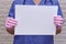 A female doctor holds an empty blank sheet, copy space for the text. Hands of a nurse in protective medical gloves with a white