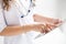 Female doctor holds folder with papers, dressed in white gown, cures people, prescribes medicine to patient, stands alone against