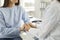 Female doctor holds hand of female patient, comforting her, expressing sympathy and support.