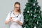 A female doctor holds pills in background of a Christmas tree. Treatment of digestion from overeating during the