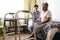 Female doctor interacting with senior female patient at retirement home