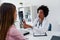 Female doctor looking at test results of her patient. Doctor and patient talking over a medical test result.