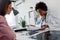 Female doctor looking at test results of her patient. Doctor and patient talking over a medical test result.