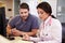 Female Doctor With Male Nurse Working At Nurses Station