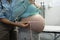 Female doctor measuring pregnant woman belly in examination room