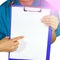 Female doctor in medical gown holding health card on notepad folder, isolated on white background. Healthcare personnel medicine