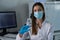 Female doctor with medical mask and gloves prepares prefilled syringe for injection by removing cap