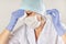 Female doctor in medical mask and gloves wipes sweat from his forehead with a napkin