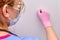 A female doctor in a medical mask knocks on the door of a patient with a coronavirus. Close-up of a nurse in protective gloves